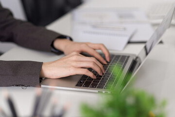 Close-up, a business woman typing on laptop keyboard