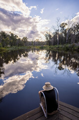 Obraz premium woman contemplating quietly by platypus pool. sky reflections.Boonoo Boonoo National Park