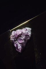 purple amethyst crystal formation with dark black background