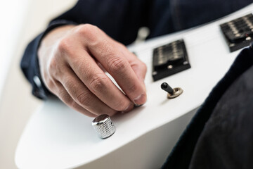Close up man push switch turn on electric guitar and playing music in living room at home. Relaxing...