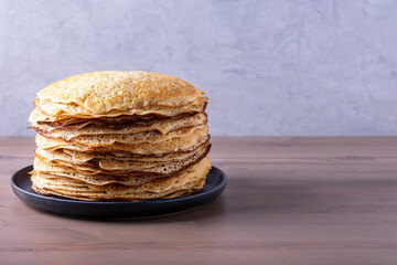 Stack of freshly baked pancakes. Russian traditional food. Shrovetide, folk festival with delicious food. Selective focus, copy space.
