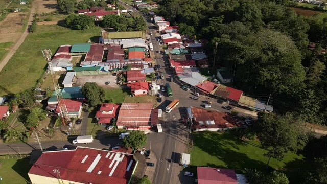 4k drone footage of downtown Los Angeles de la Fortuna. Small Costa Rican town close by the Arenal volcano. Multiple busses driving and stopping along the main road that leads to Liberia.