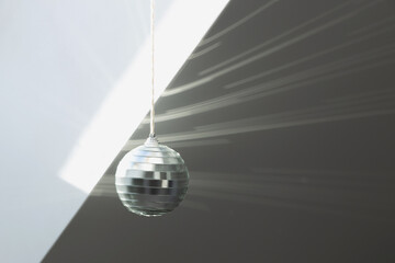 Silver disco ball reflects sunlight on silver background. Motion blur.