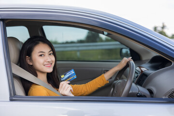 Young beautiful asian women getting new car. Hand holding credit card payment. Car owner paying...