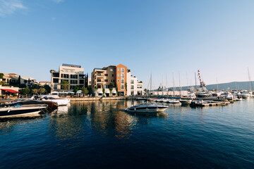 Fototapeta na wymiar Modern club houses next to the yacht marina in the resort of Porto. Montenegro