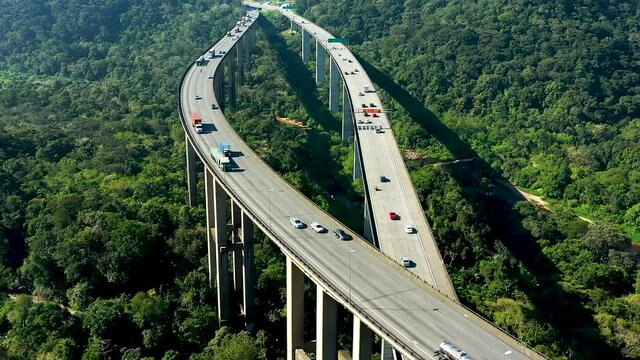 Aerial landscape of landmark highway road at green forest trees and mountains. Traffic at famous road way to brazilian south coast. Legendary engineering construction. Brazilian road landmark.