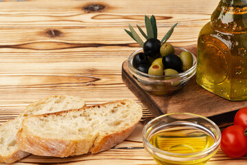 Italian ciabatta bread with olive oil on wooden background