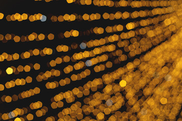 Christmas light garland on dark background. Blurred image. Wallpaper.