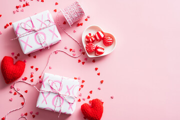 Happy Valentines Day concept. Overhead view of gift boxes, red hearts, sweets on pink background.