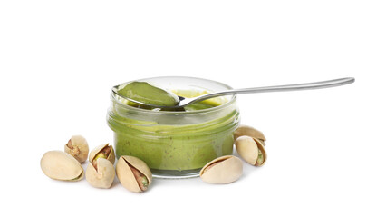 Jar and spoon with delicious pistachio butter on white background