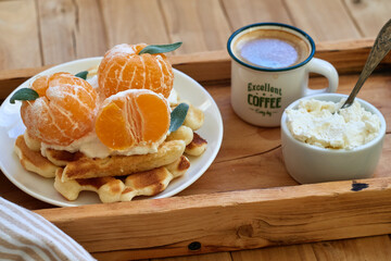Belgian waffles with tangerine. Side view, wooden background. Rustic. horizontal