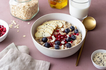 Oatmeal porridge with apple, pomegranate, blueberries and almonds. Healthy eating. Vegetarian food. Breakfast.