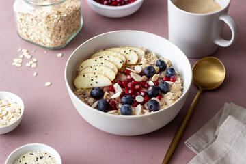 Oatmeal porridge with apple, pomegranate, blueberries and almonds. Healthy eating. Vegetarian food. Breakfast.