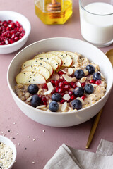 Oatmeal porridge with apple, pomegranate, blueberries and almonds. Healthy eating. Vegetarian food. Breakfast.