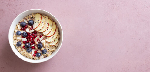 Oatmeal porridge with apple, pomegranate, blueberries and almonds. Healthy eating. Vegetarian food....
