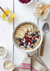 Oatmeal porridge with apple, pomegranate, blueberries and almonds. Healthy eating. Vegetarian food. Breakfast.