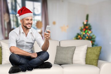 Young happy man making video call over the smart phone on Christmas Eve at home.