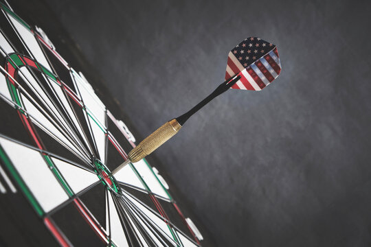 Concept achieving goal.Achieving goals in business, politics and life.Dartboard with darts painted with American flag stuck right into target.