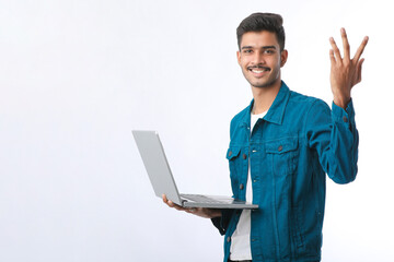 Young indian man using laptop on white background.