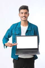 Young indian man showing laptop screen on white background.