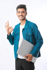 young indian man holding laptop in hand on white background.