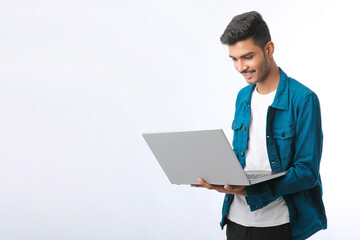 Young indian man using laptop on white background.