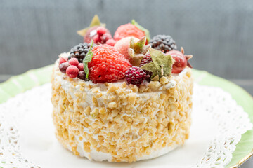 layer cake Napoleon with berries assortment on a plate of the windowshop. Sweet dessert for celebration