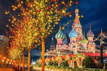 Fototapeta Moscow Christmas. Russia winter. St. Basil's Cathedral on Christmas night. Winter evening on Red Square. New Year's fair in front of Kremlin. Tour to Russia. Travel to Moscow. Trees with garlands obraz
