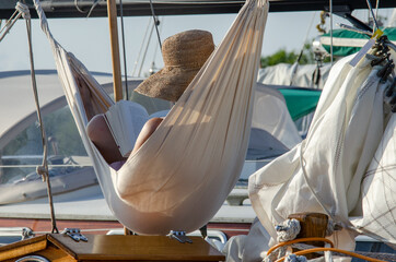 Frau entspannt beim Lesen in der Hängematte auf einem Segelboot