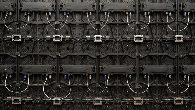 Backside of big LED screen monitor display. Power input and output wire and data input and output plug