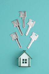 House keys and miniature house model on a colorful bright background. Top view, flat lay. Home buying concept.