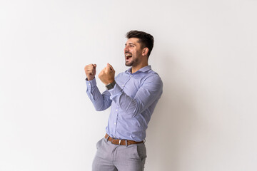 Portrait of a satisfied young man celebrating success over white background