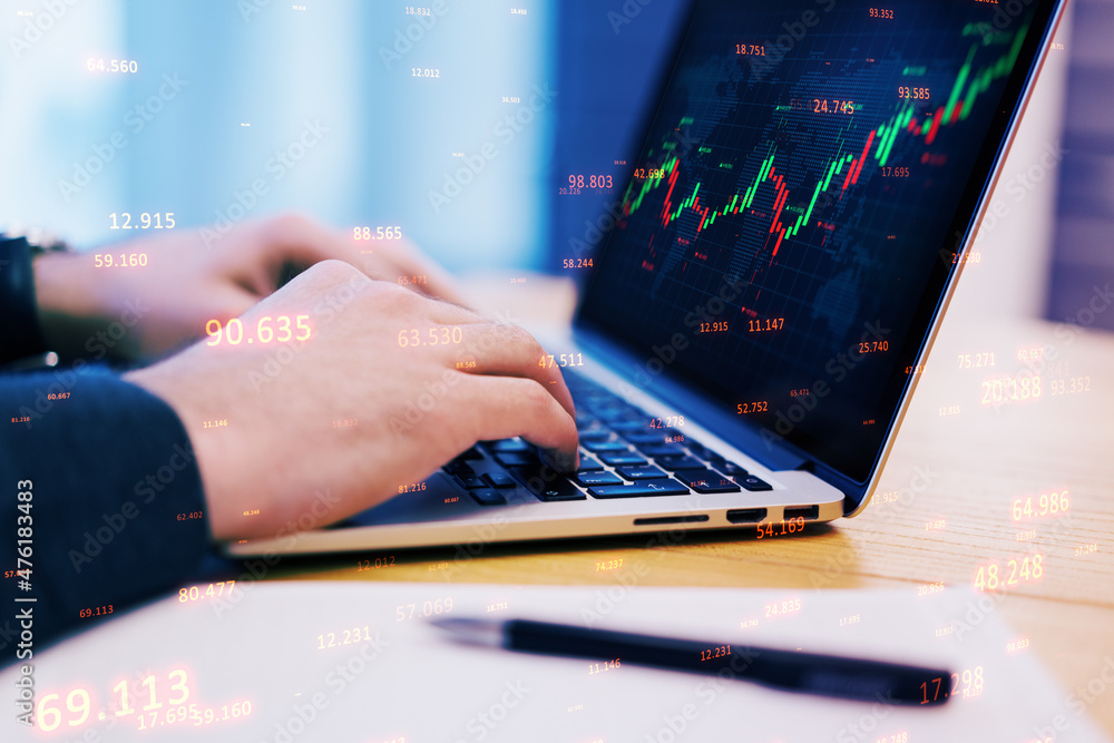 Poster close up of male hands using laptop with abstract candlestick forex graph and bid data numbers on bl