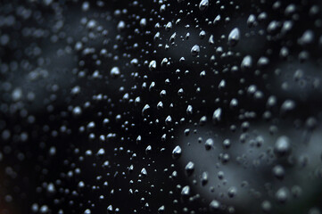 The deep water droplets on the black surface and some of the water droplets are blurry