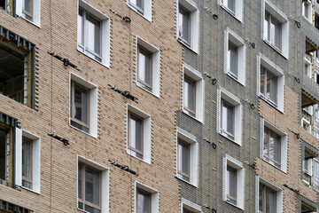 Facing building with ventilated facade. Monolithic concrete frame of apartment building under...