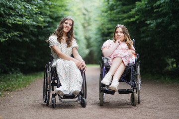 Plakat Two caucasian women in wheelchairs posing on camera among green city park. Female friends who live with disability having hairstyle and wearing beautiful summer dresses.