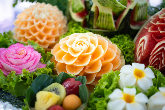 Handmade carved cantaloupe or melon as a beautiful flower for special event decoration. Food object photo. Close-up and selective focus.