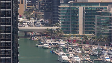 Many yachts and boats are parked in harbor aerial timelapse in Dubai Marina