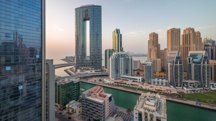 Fototapeta premium Dubai Marina skyscrapers and JBR district with luxury buildings and resorts aerial day to night timelapse