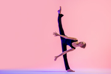 Young teenager dancer dancing on a red studio background. Ballet, dance, art, modernity, choreography concept