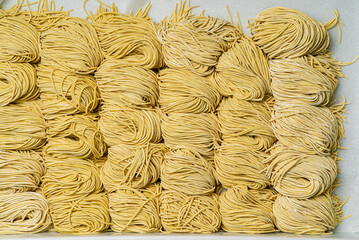  Dried egg noodles in wooden blocks isolated on white background.