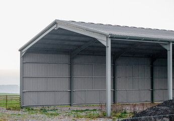 large empty corrugated barn with low cloud background, Wiltshire UK