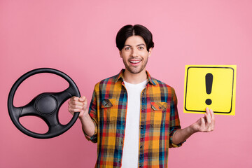 Photo of excited pretty guy dressed checkered clothes smiling driving car holding exclamation point...