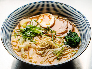 Asian noodles soup, ramen with chicken, tofu, vegetables and egg, close-up.