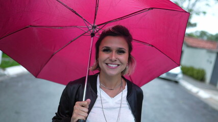 Woman walking outside with red umbrella during drizzle rain