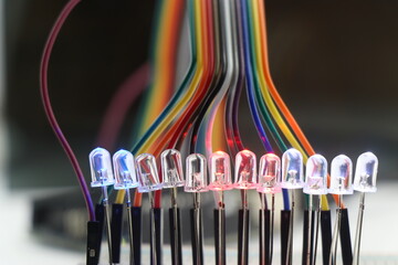 Light emitting diode or LED with glowing lights arranged in a breadboard and connected with jumper...