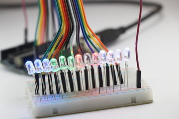 LED lights emitting multiple colors connected in a parallel circuit on a breadboard controlled by...
