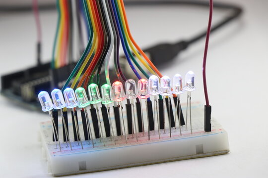 LED lights emitting multiple colors connected in a parallel circuit on a breadboard controlled by micro controller connected with jumper wires