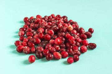 The concept of using quick-frozen berries. Red cranberry berry in a frozen state on a light background close-up.