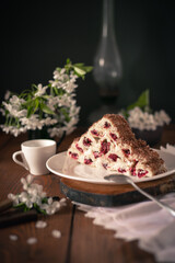 Homemade cake with cherries and cream on a wooden table.